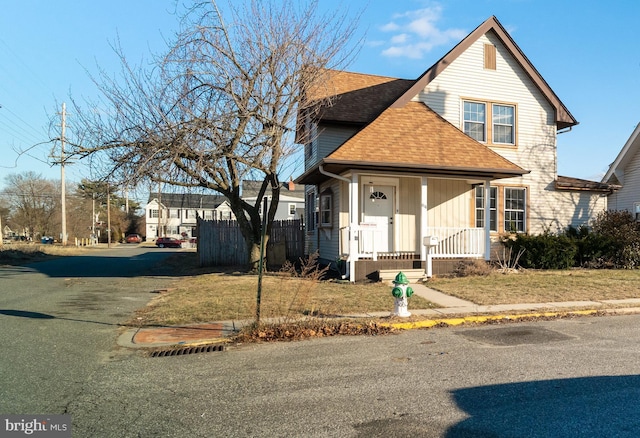 front facade with covered porch and a front yard