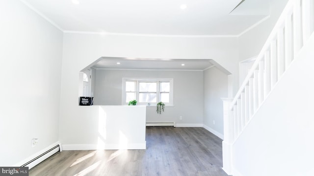 unfurnished room featuring a baseboard heating unit, hardwood / wood-style floors, and ornamental molding