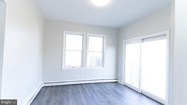 spare room featuring light wood-type flooring and a baseboard radiator