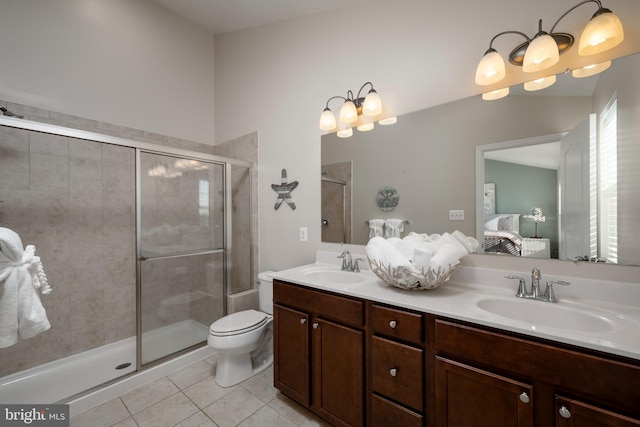 bathroom featuring toilet, a shower with door, vanity, and tile patterned floors