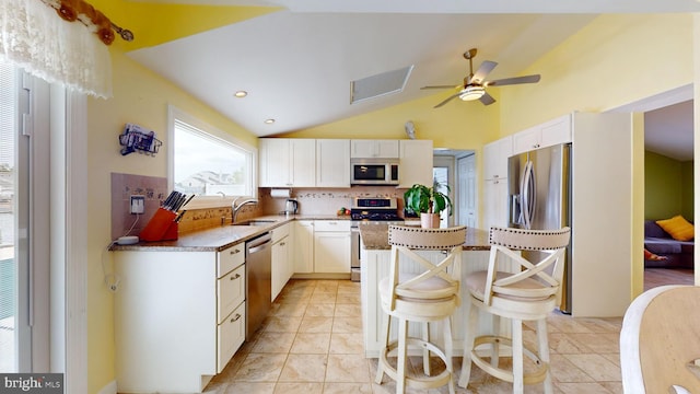 kitchen with white cabinets, appliances with stainless steel finishes, tasteful backsplash, and sink