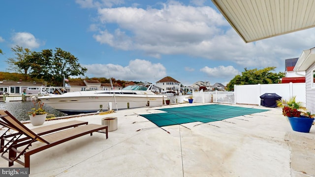 view of swimming pool featuring a water view, a grill, and a patio area