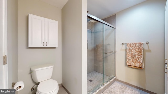 bathroom with toilet and a shower with door