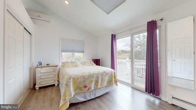 bedroom with access to outside, a baseboard radiator, a wall mounted air conditioner, and a closet