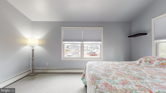 bedroom with a baseboard heating unit and multiple windows