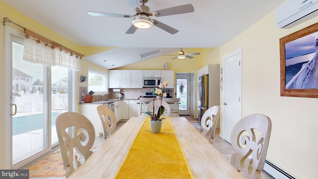 dining room with baseboard heating, an AC wall unit, ceiling fan, sink, and lofted ceiling