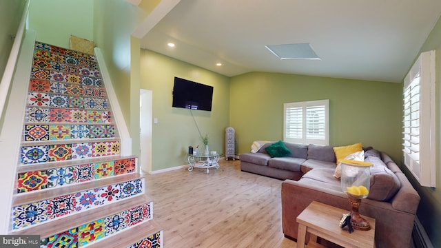 living room with baseboard heating, vaulted ceiling, and light hardwood / wood-style flooring