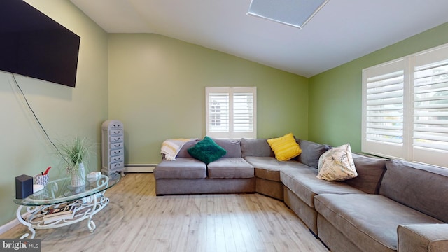 living room featuring lofted ceiling, a baseboard heating unit, and light hardwood / wood-style floors