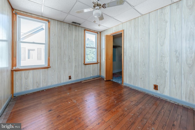 unfurnished room with a drop ceiling, ceiling fan, and dark hardwood / wood-style flooring