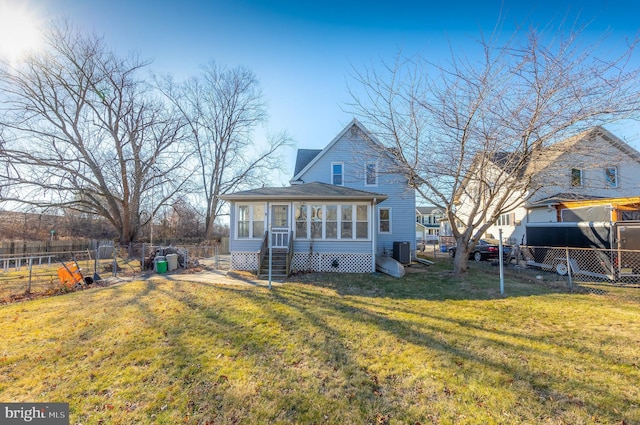 rear view of property with a yard, central air condition unit, and a sunroom