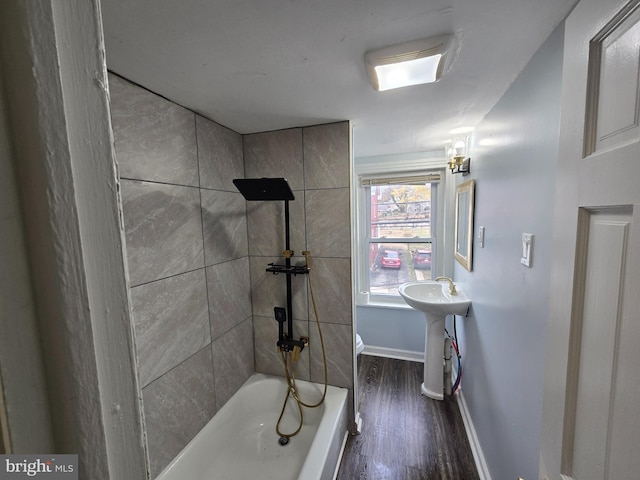 bathroom with sink, a bathtub, hardwood / wood-style floors, and toilet