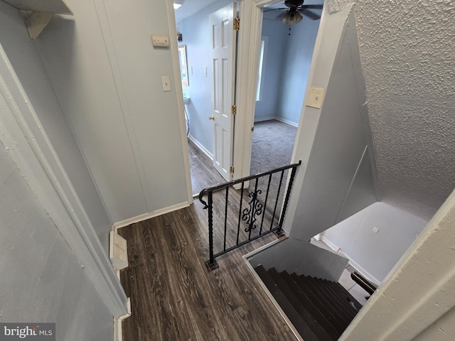 stairway with wood-type flooring and ceiling fan