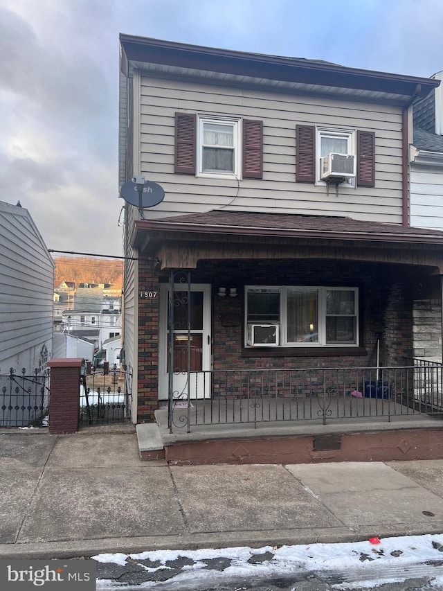 view of front of house featuring covered porch and cooling unit