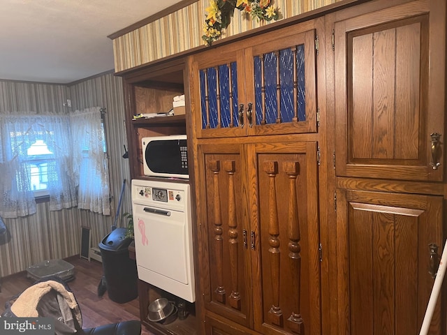 clothes washing area featuring stacked washer / drying machine and hardwood / wood-style flooring