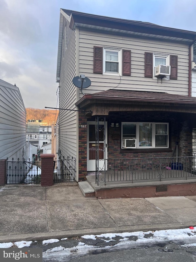 view of front of property featuring cooling unit and a porch