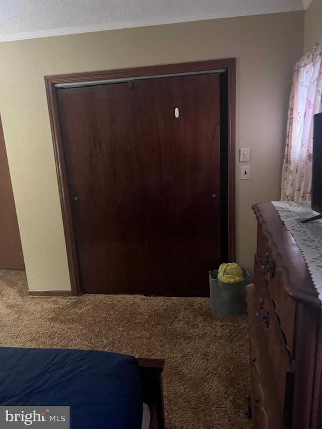 bedroom featuring a closet, carpet flooring, and ornamental molding