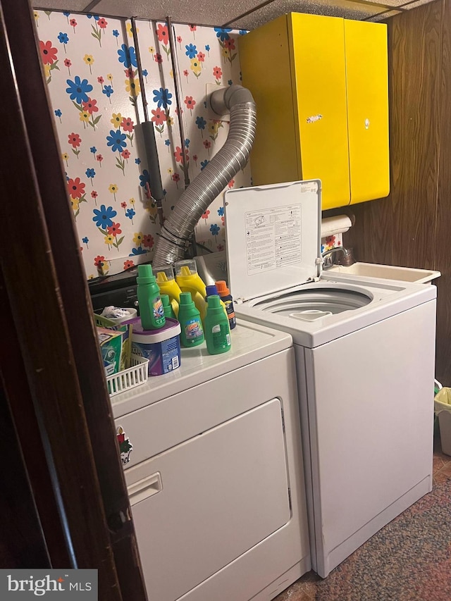 clothes washing area with washer and clothes dryer and a textured ceiling