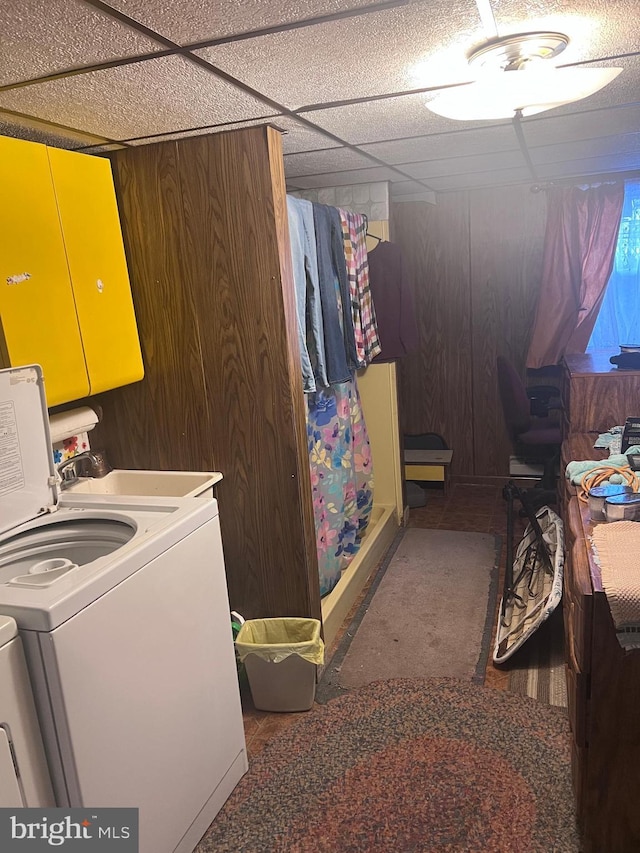 laundry area with cabinets, washer and clothes dryer, and wooden walls