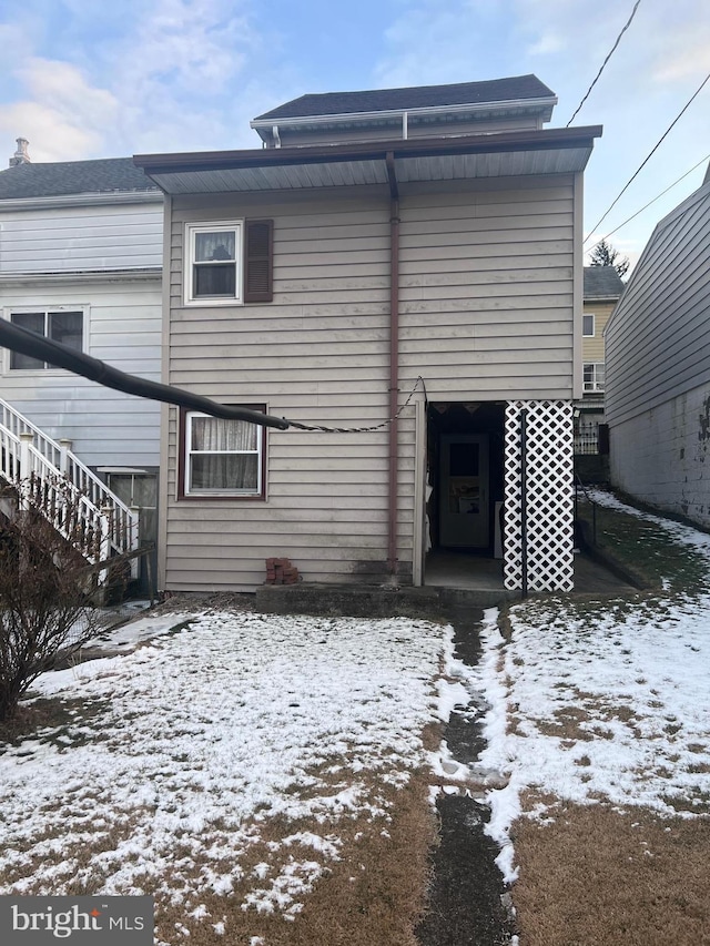 view of snow covered rear of property