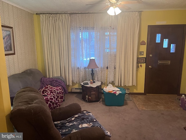 living area with carpet, a textured ceiling, a baseboard heating unit, ornamental molding, and ceiling fan