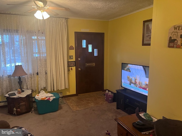 entryway featuring ceiling fan, a textured ceiling, ornamental molding, and carpet floors