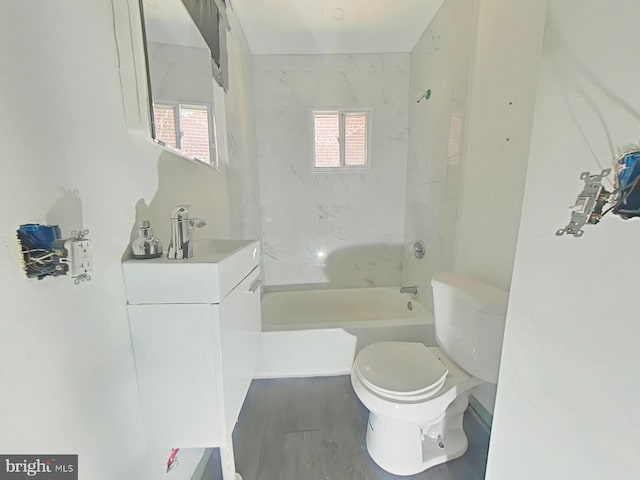 full bathroom with toilet, a healthy amount of sunlight, tiled shower / bath, and vanity