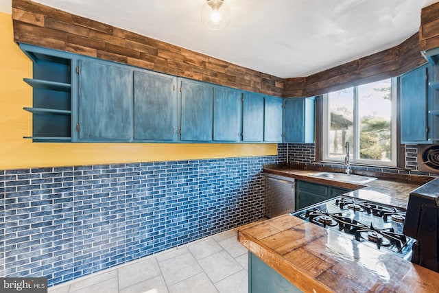 kitchen featuring sink, dishwasher, tile walls, and light tile patterned floors