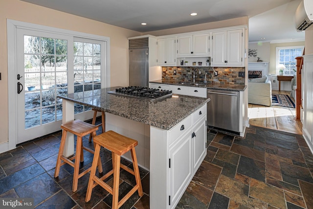 kitchen with sink, a center island, white cabinets, and appliances with stainless steel finishes