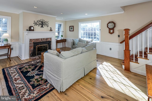 living room with ornamental molding, a fireplace, and light hardwood / wood-style flooring