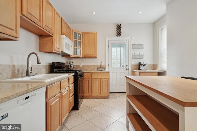 kitchen featuring white appliances, light tile patterned flooring, a healthy amount of sunlight, and sink