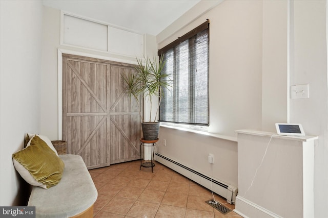 sitting room with baseboard heating and light tile patterned floors