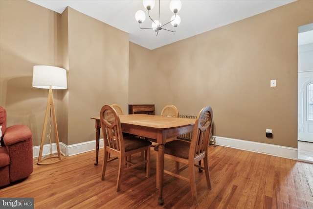 dining space with a notable chandelier and light hardwood / wood-style floors