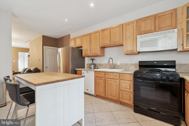 kitchen with white appliances, a center island, light brown cabinetry, and sink