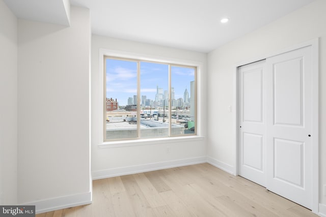 unfurnished bedroom with light wood-type flooring and a closet