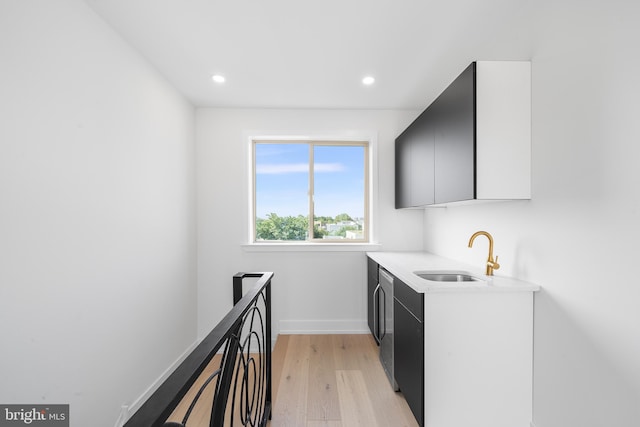 washroom with light hardwood / wood-style floors and sink