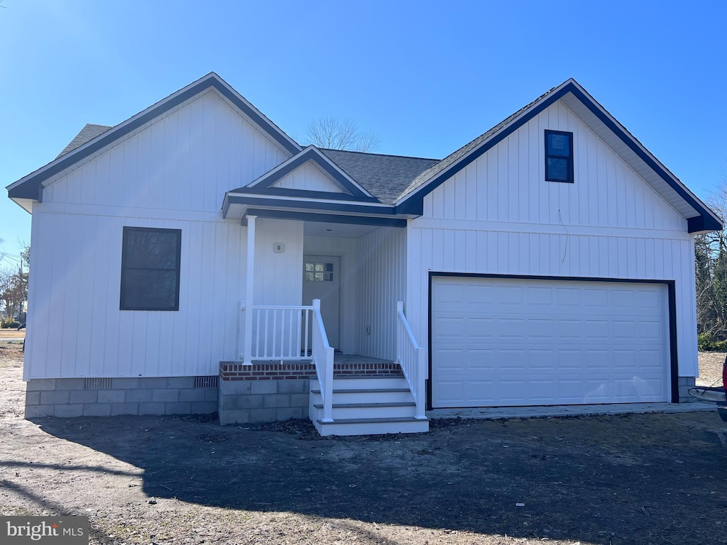 view of front of house with a garage and a shingled roof