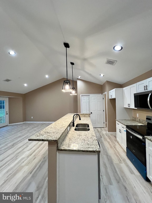 kitchen featuring electric range, light wood-type flooring, visible vents, stainless steel microwave, and a sink