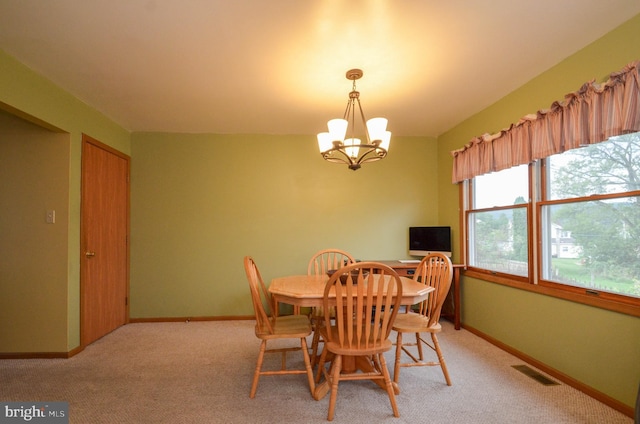 dining room featuring light colored carpet and an inviting chandelier