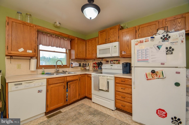 kitchen featuring white appliances and sink