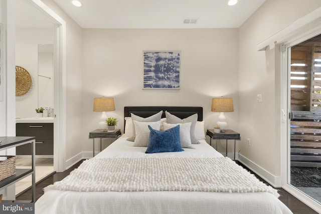 bedroom with dark wood-type flooring and connected bathroom