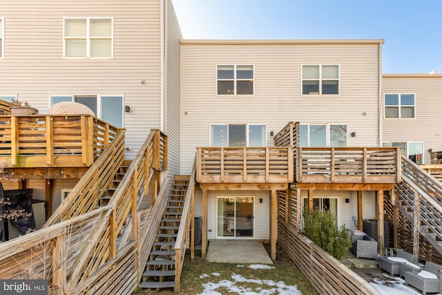 rear view of property with a wooden deck and a patio area