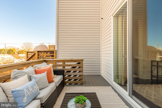 wooden balcony with a wooden deck and an outdoor hangout area