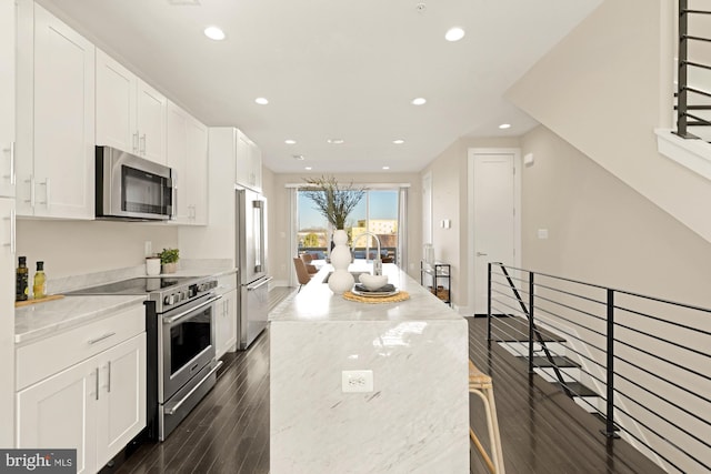 kitchen with white cabinetry, light stone countertops, and stainless steel appliances