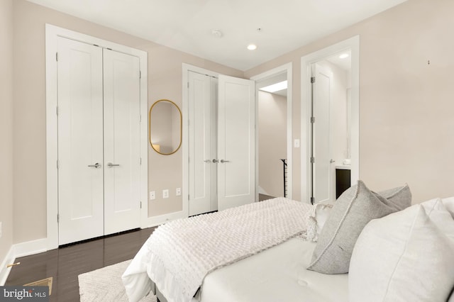 bedroom featuring multiple closets and dark hardwood / wood-style flooring