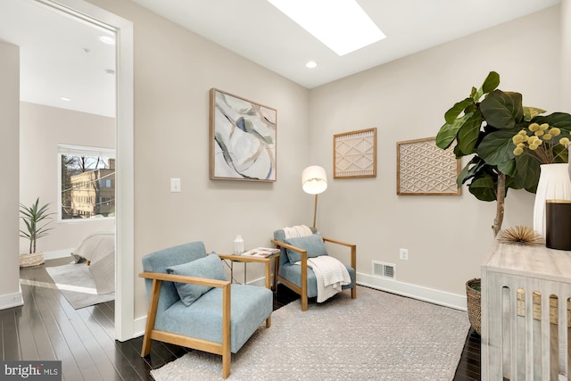 living area featuring dark hardwood / wood-style floors and a skylight