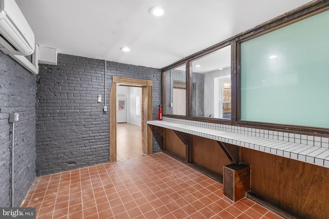 interior space with brick wall and an AC wall unit