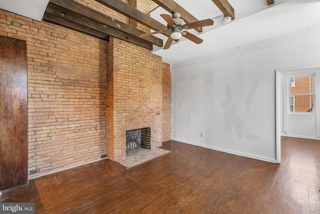 unfurnished living room with brick wall, a fireplace, ceiling fan, dark wood-type flooring, and beam ceiling