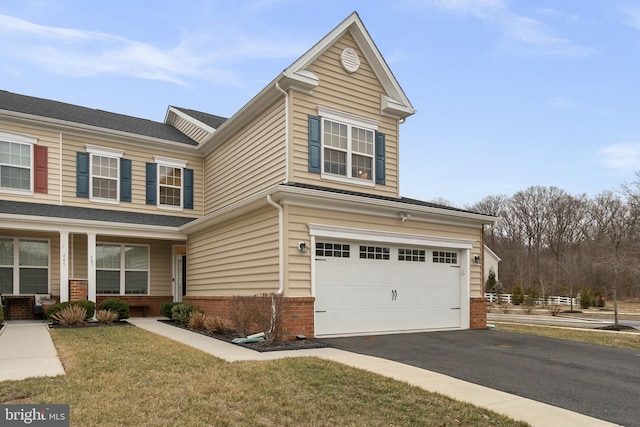 traditional-style home featuring brick siding, driveway, an attached garage, and a porch