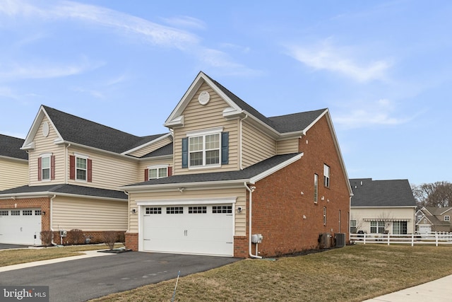 view of front facade featuring fence, driveway, a front lawn, a garage, and brick siding