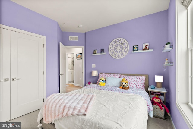 bedroom with light carpet, a closet, and multiple windows